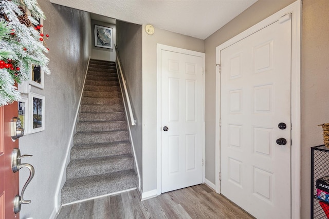 staircase with hardwood / wood-style flooring