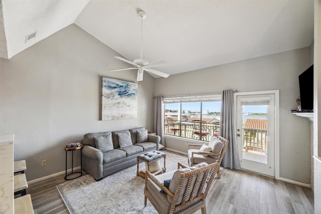 living room featuring ceiling fan, hardwood / wood-style floors, and vaulted ceiling