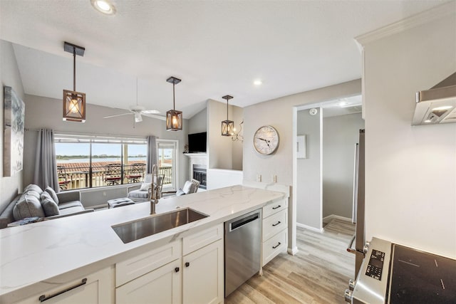 kitchen featuring light stone countertops, sink, stainless steel dishwasher, pendant lighting, and white cabinets