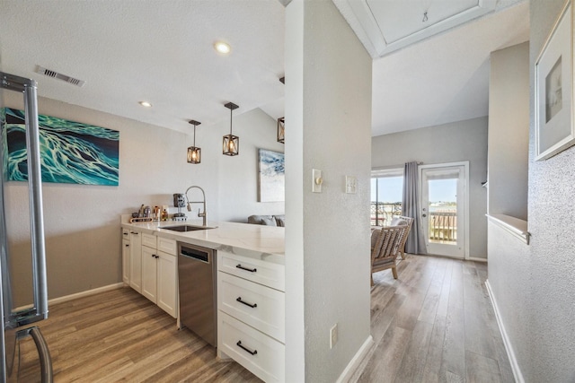 kitchen with light stone countertops, dishwasher, sink, light hardwood / wood-style flooring, and white cabinets