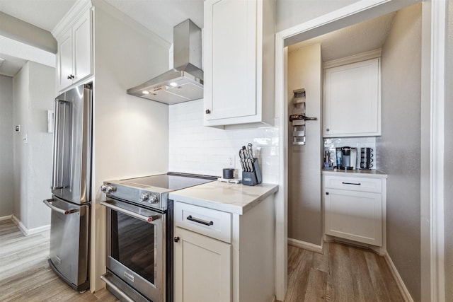 kitchen with backsplash, light hardwood / wood-style flooring, appliances with stainless steel finishes, white cabinetry, and island exhaust hood