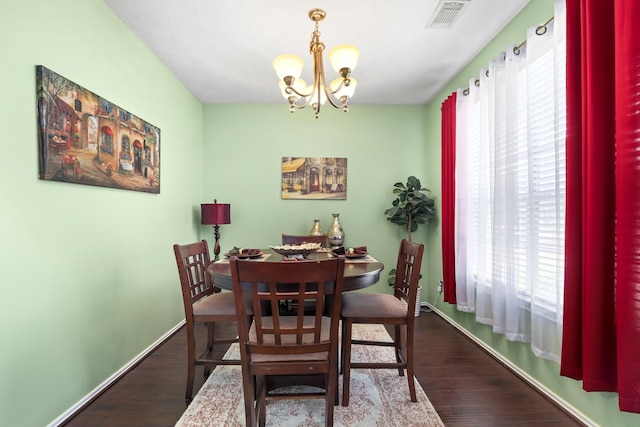 dining area featuring hardwood / wood-style flooring and a chandelier