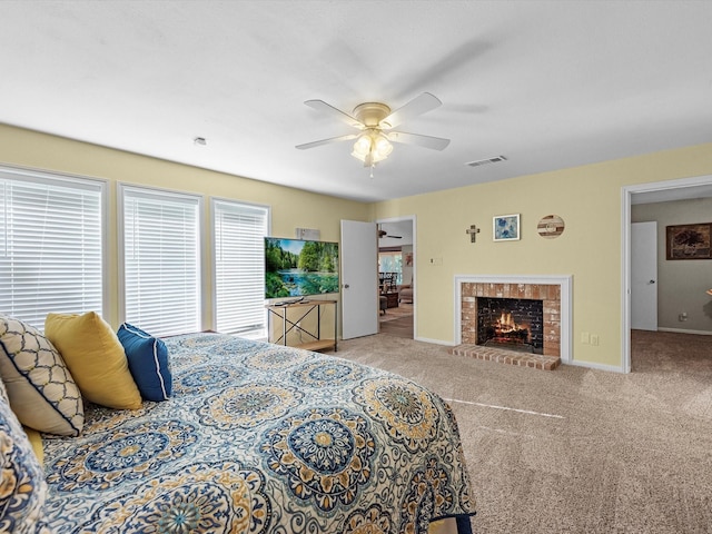 bedroom with light carpet, ceiling fan, and a fireplace