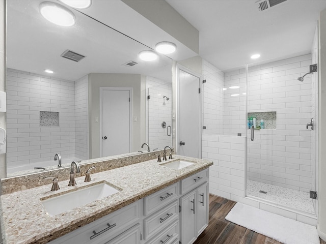 bathroom with hardwood / wood-style floors, vanity, and a shower with shower door