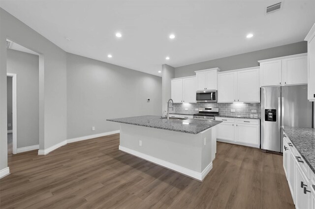 kitchen with a center island with sink, dark hardwood / wood-style flooring, white cabinetry, and appliances with stainless steel finishes