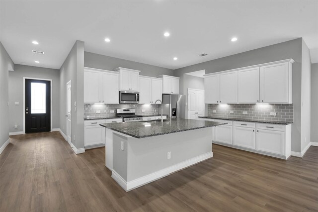 kitchen featuring white cabinets, dark hardwood / wood-style flooring, a kitchen island with sink, and appliances with stainless steel finishes