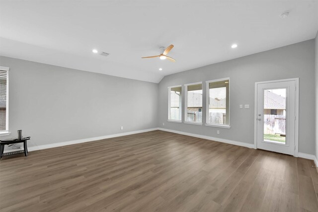 spare room with dark hardwood / wood-style floors, ceiling fan, and vaulted ceiling