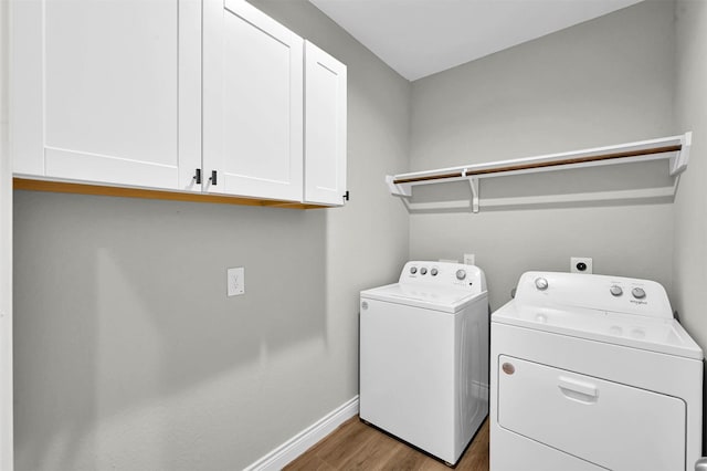 laundry room with cabinets, independent washer and dryer, and light wood-type flooring