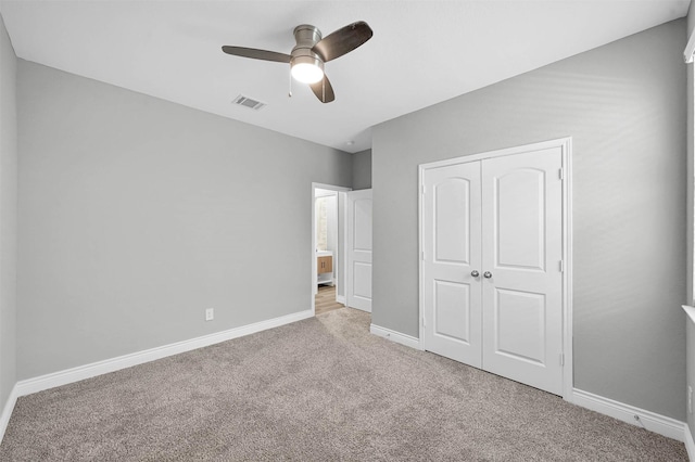 unfurnished bedroom with ceiling fan, light colored carpet, and a closet