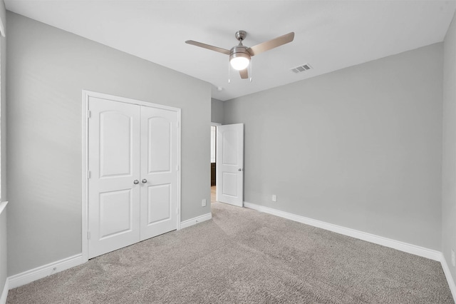 unfurnished bedroom featuring carpet, ceiling fan, and a closet