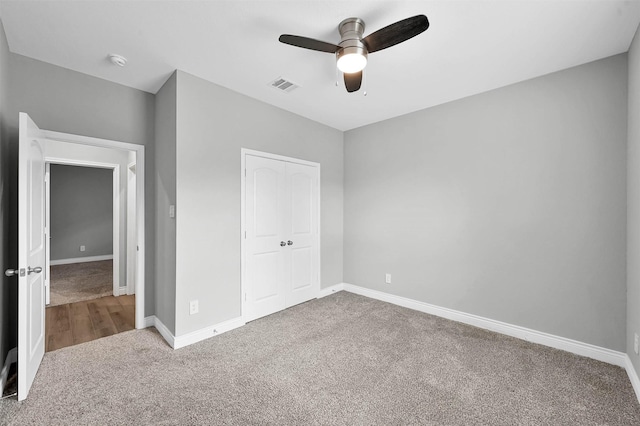 unfurnished bedroom featuring carpet floors, a closet, and ceiling fan