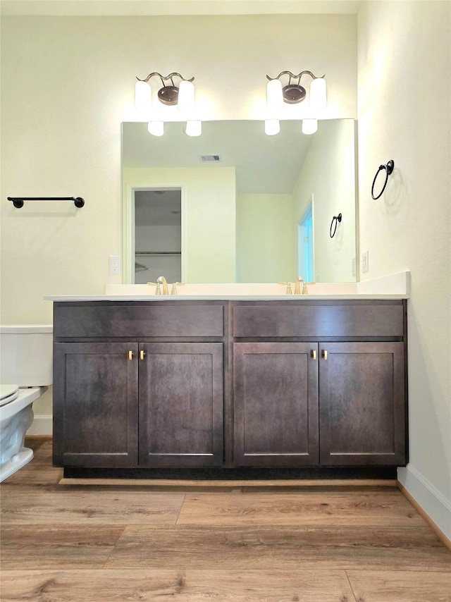 bathroom with vanity, toilet, and wood-type flooring