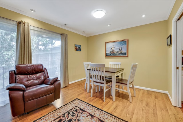 dining room featuring light wood-type flooring and crown molding