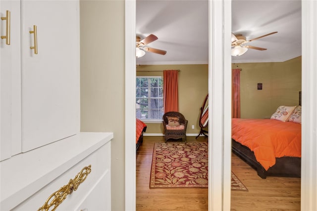 bedroom featuring hardwood / wood-style flooring, ceiling fan, and crown molding