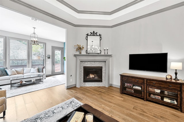 living room with a chandelier, crown molding, and wood-type flooring