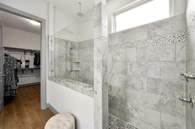 bathroom featuring hardwood / wood-style floors and a tile shower