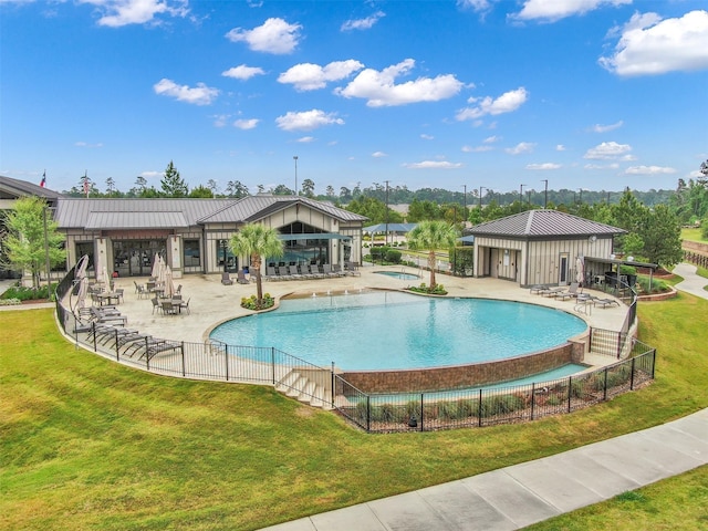 view of swimming pool featuring a patio area and a yard