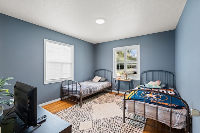 bedroom with hardwood / wood-style floors and a textured ceiling