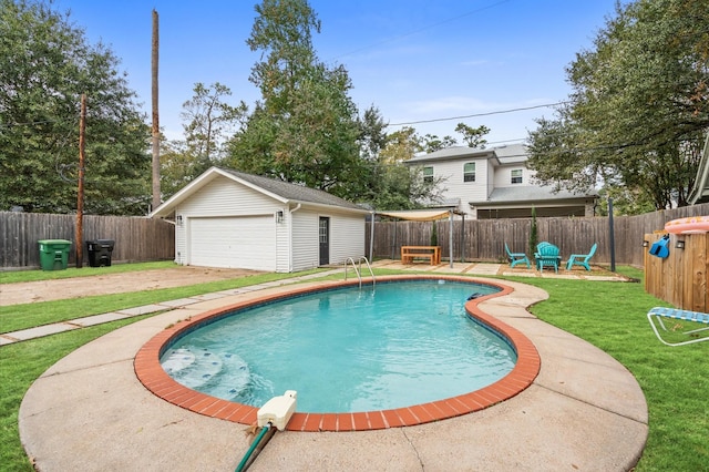 view of pool featuring a garage, an outdoor structure, and a yard