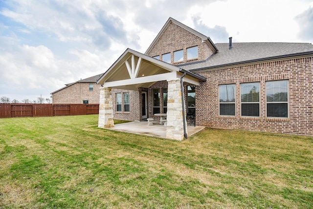 back of house with a patio area and a yard