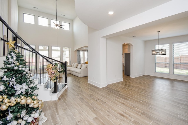 interior space featuring a chandelier, a healthy amount of sunlight, a high ceiling, and light hardwood / wood-style floors