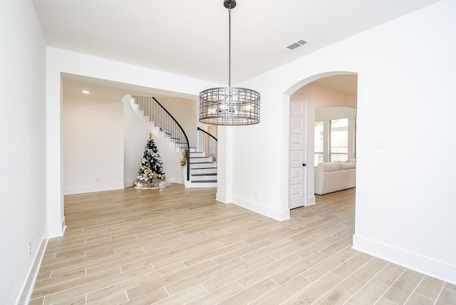 unfurnished room featuring a chandelier