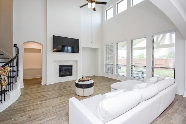 living room with ceiling fan and a towering ceiling