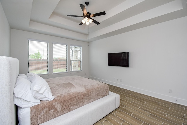 bedroom featuring ceiling fan and a raised ceiling