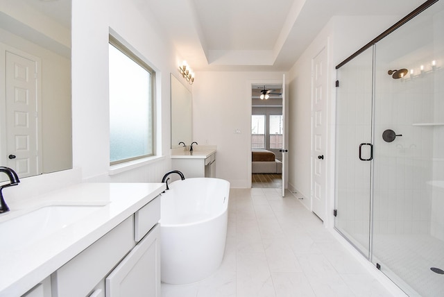 bathroom with vanity, a tray ceiling, ceiling fan, and independent shower and bath