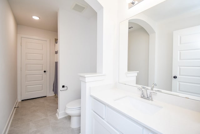 bathroom featuring tile patterned floors, vanity, and toilet