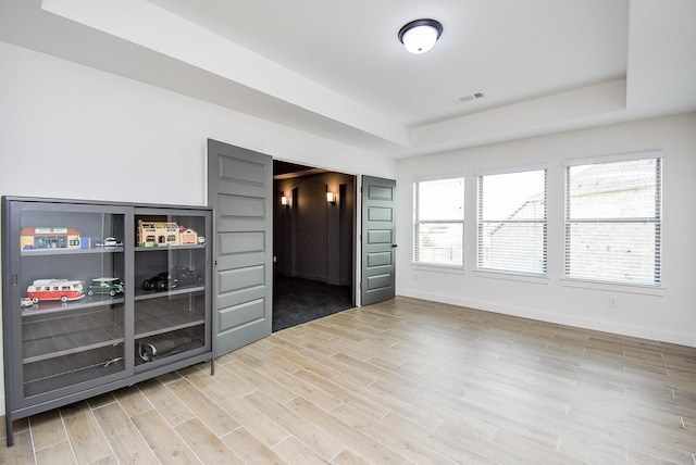 interior space with hardwood / wood-style floors and a tray ceiling