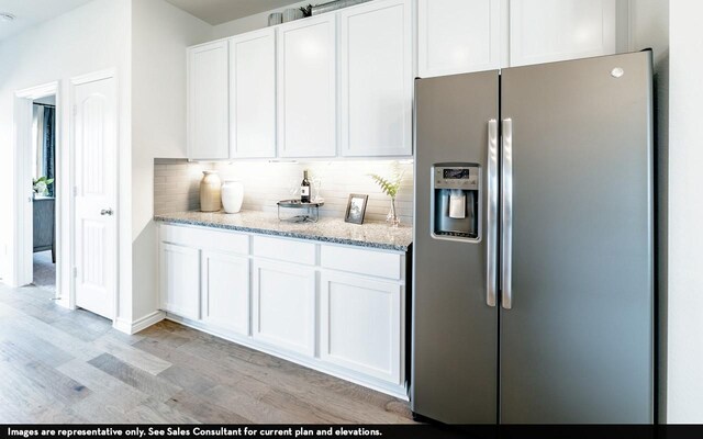 kitchen featuring tasteful backsplash, stainless steel fridge, white cabinets, and light hardwood / wood-style floors