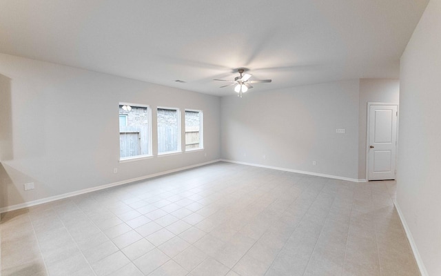 spare room with ceiling fan and light tile patterned floors