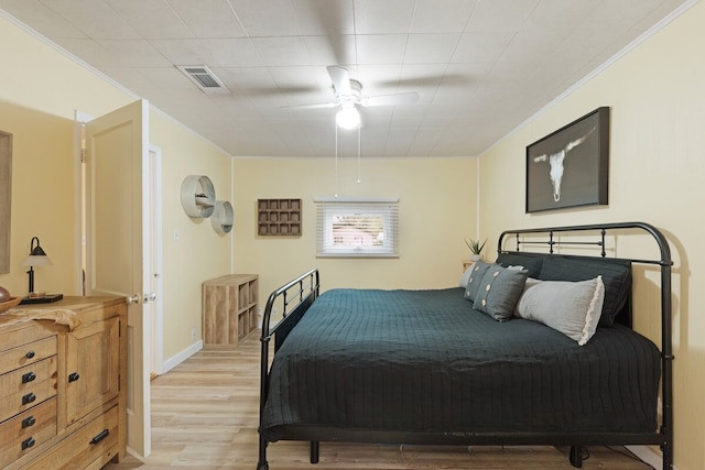 bedroom featuring ceiling fan, ornamental molding, and light hardwood / wood-style flooring