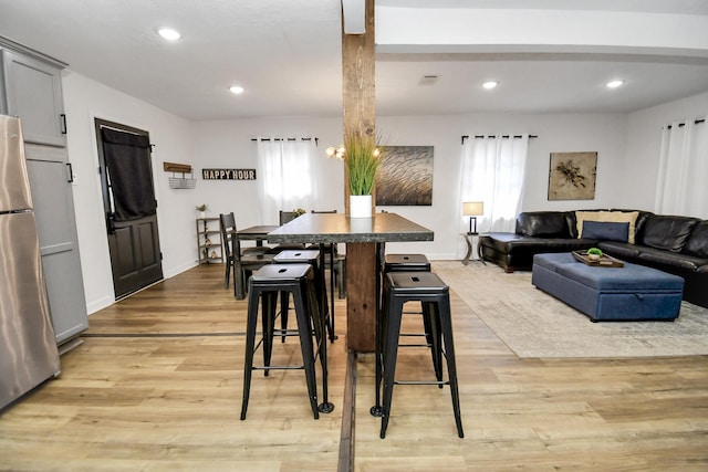 dining area with light hardwood / wood-style floors and a healthy amount of sunlight