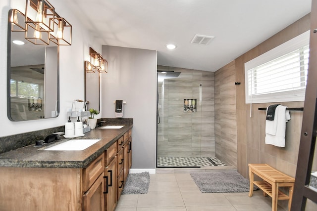 bathroom featuring tile patterned flooring, vanity, and tiled shower