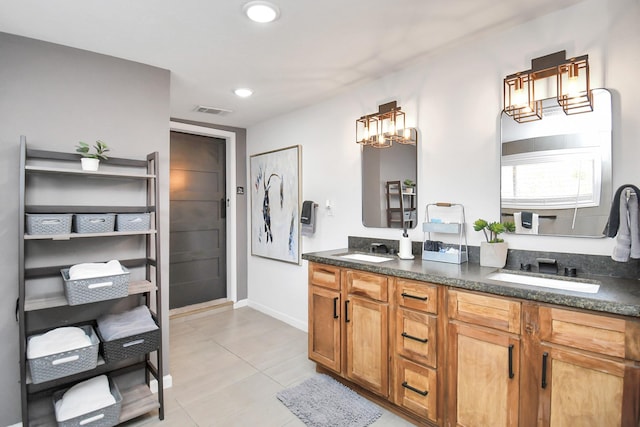 bathroom featuring tile patterned floors, vanity, and a notable chandelier