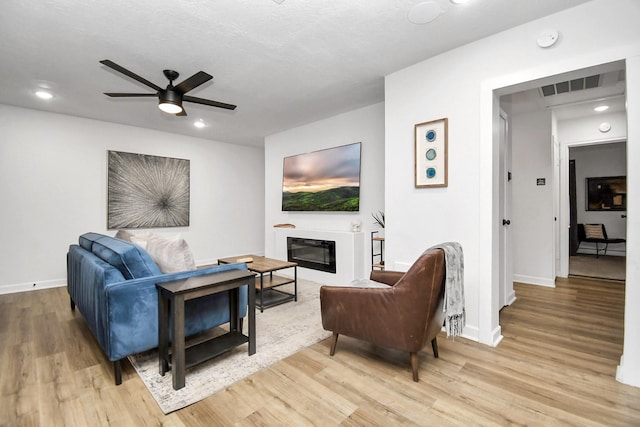 living room with ceiling fan and light wood-type flooring