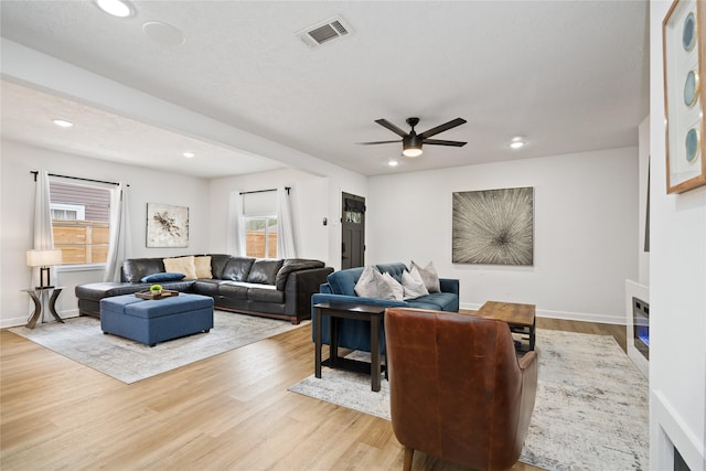 living room featuring light hardwood / wood-style flooring and ceiling fan