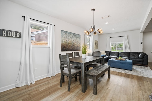 dining room with a notable chandelier and light wood-type flooring