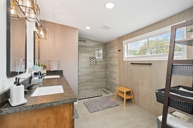 bathroom featuring tiled shower, vanity, and tile patterned floors