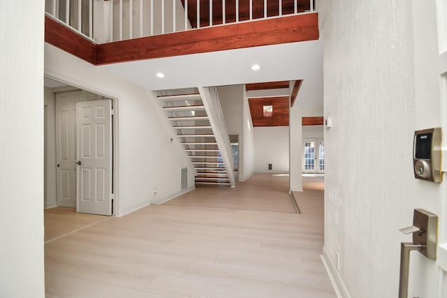 interior space featuring light hardwood / wood-style flooring and beamed ceiling