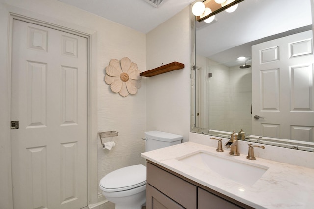 bathroom with a shower, vanity, and toilet