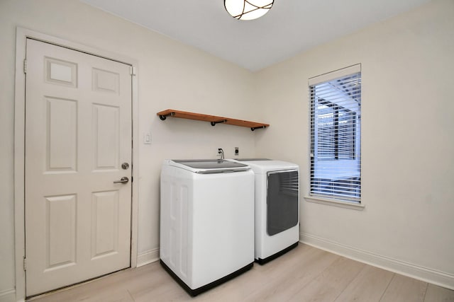 washroom with separate washer and dryer and light hardwood / wood-style flooring