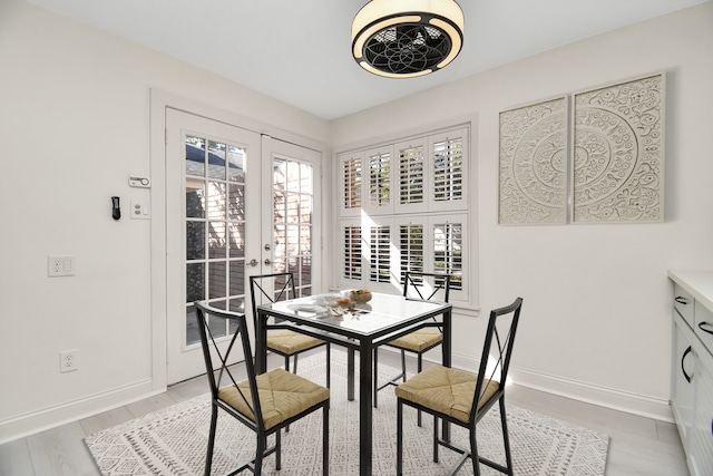 dining area with french doors and light hardwood / wood-style floors