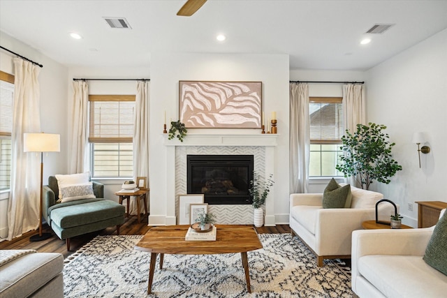 living room with a tile fireplace, hardwood / wood-style floors, and ceiling fan