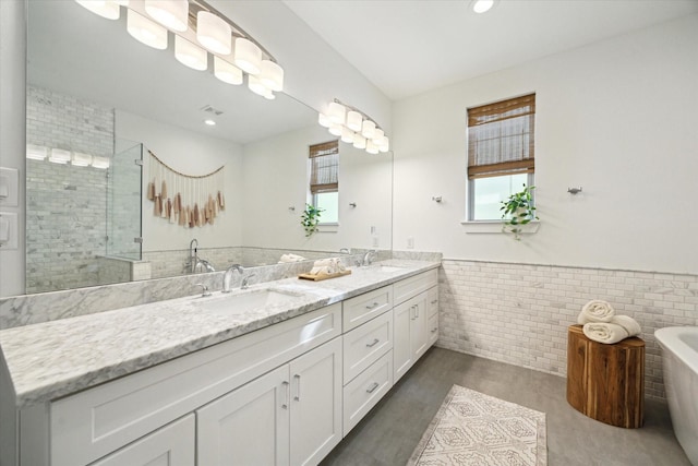 bathroom featuring plenty of natural light, tile walls, and walk in shower