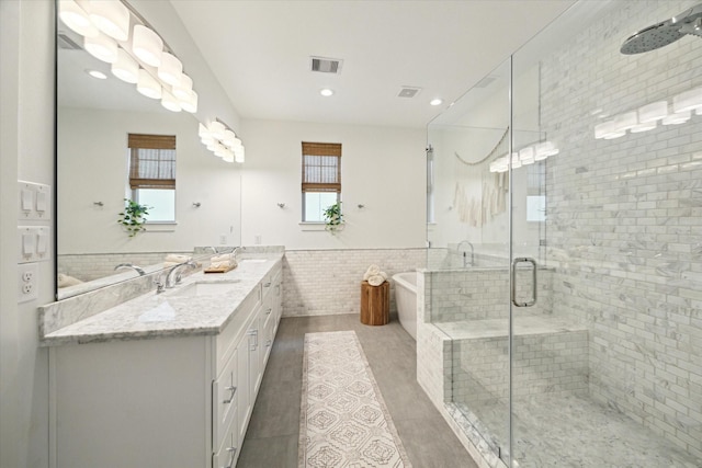 bathroom with hardwood / wood-style floors, vanity, an enclosed shower, and tile walls