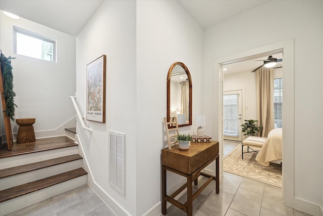 hall featuring a healthy amount of sunlight and light tile patterned floors