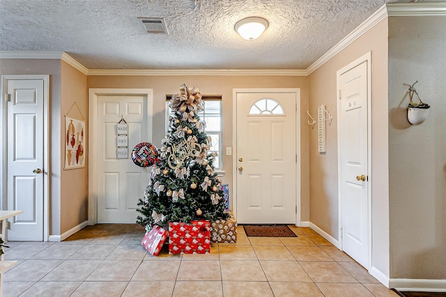 foyer with light tile patterned floors, a textured ceiling, and crown molding